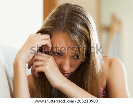 Portrait of upset young woman suffering from troubles in private