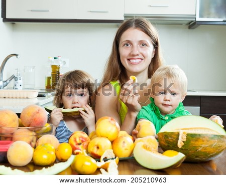 Ordinary family eating melon and other fruits over  table at home interior