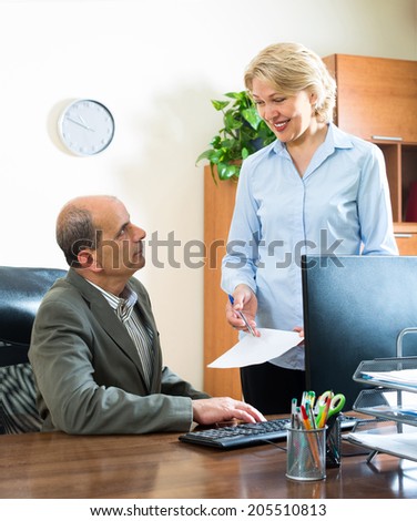 Ordinary office scene with two aged co-workers