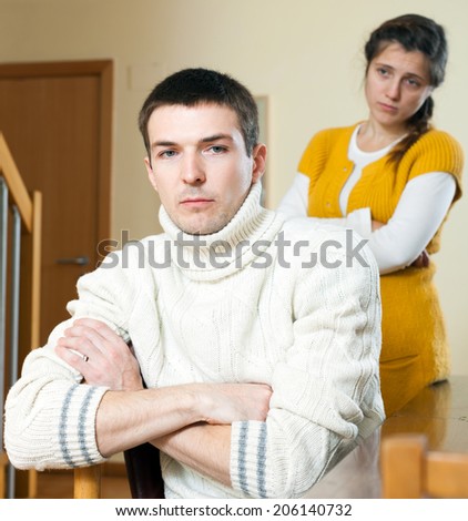 Family conflict. Sad young  ordinary man listening to woman
