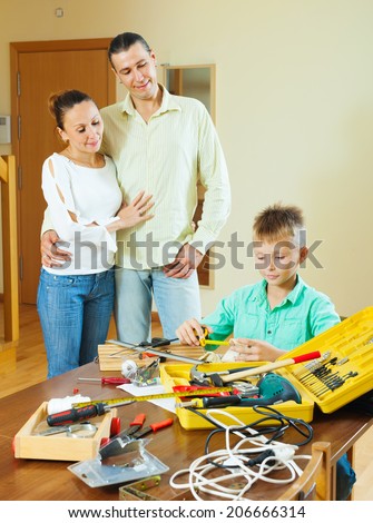 The teenager is doing something with their hands, the parents are watching