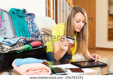 Young woman using credit card and tablet for reserving plane ticket online