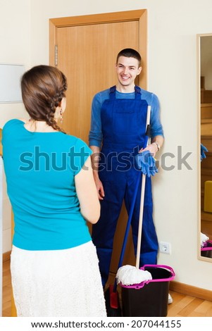 Woman meeting smiling cleaner at the door at home