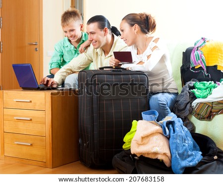 Middle-aged couple with teenage son choosing the resort on the internet using laptop at home