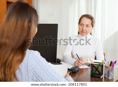 Old female employee interviewing young woman at office