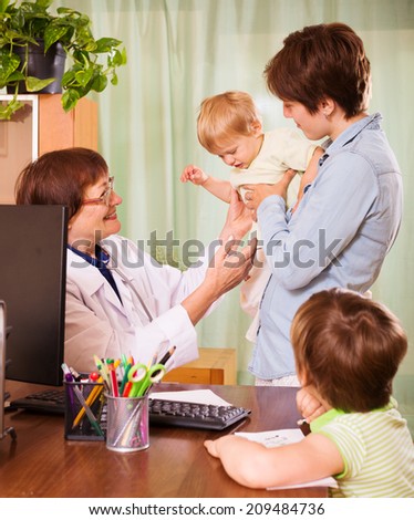 mother with two children and friendly pediatrician doctor at clinic office
