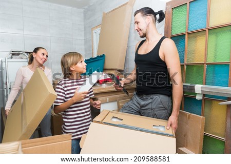 Family of three packing things before relocation