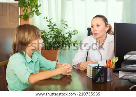 Female doctor and patient boy talking in the office