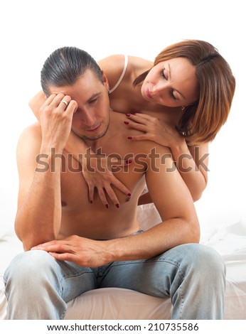 Woman consoling the depressed husband in bed at home