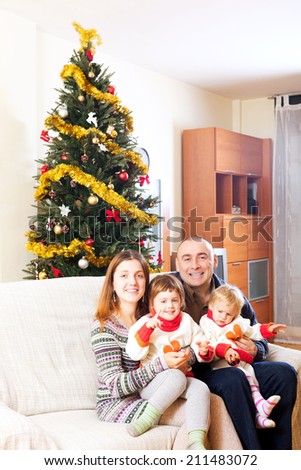 Portrait of family near Christmas tree on sofa