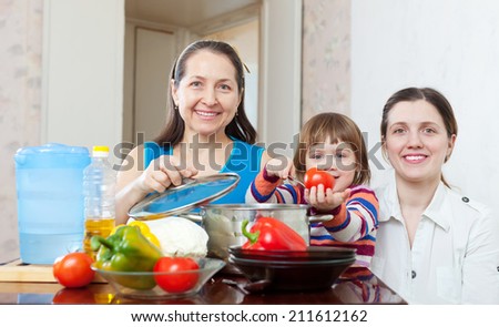 Happy family together cooking veggie lunch with vegetables at home