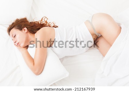 Beautiful girl in underwear sleeping on white pillow