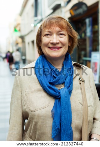 Outdoor portrait of mature woman wearing scarf in city street
