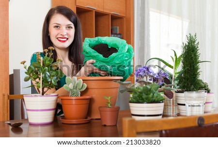 Young woman working with  flower in pots at her home