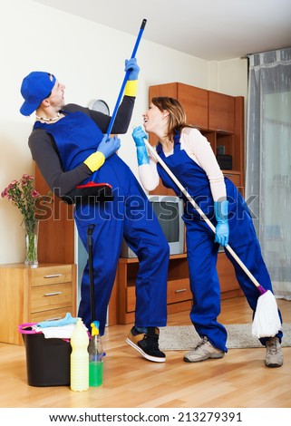 Playful housecleaners cleaning at house
