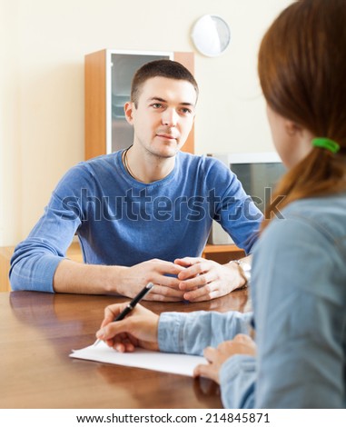 Man  filling questionnaire for employee with paper at table