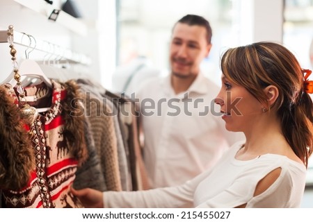 Family choosing clothes at clothing boutique together