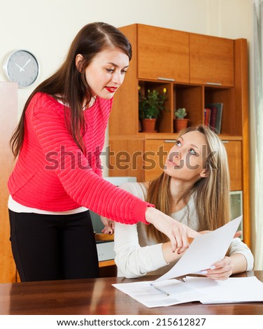 serious women with  documents at table in home or office interior