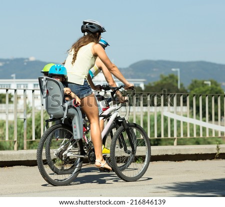 Young parents with children are traveling through the city on bikes