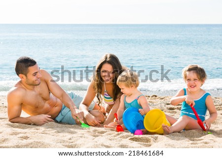 Young parents with two kids have fun at sea shore