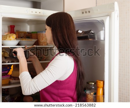 Brunette woman  near refrigerator  at home