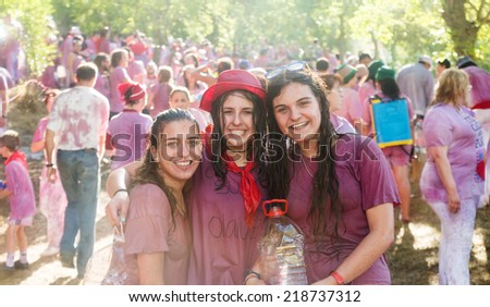 HARO, SPAIN - JUNE 29, 2014: Happy women during Batalla del vino - Haro Wine Festival, La Rioja. People fighting with wine from botas, bottles and buckets
