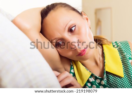 Sad and lonely middle-aged woman sitting on couch
