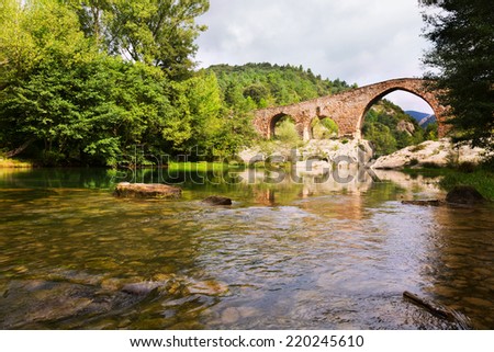 Medieval arched bridge over Llobregat river in the Pyrenees. Catalonia