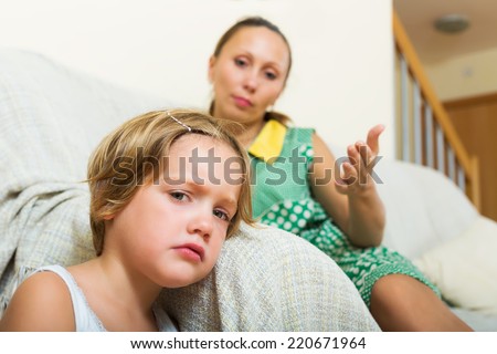 Displeased female baby-sitter and crying little girl