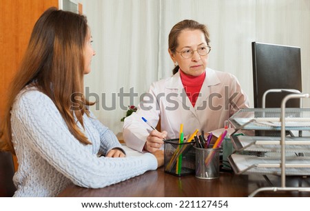 Female doctor in uniform and girl patient in clinic