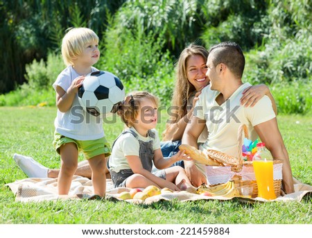 Young family with children having picnic outdoor on sunny day