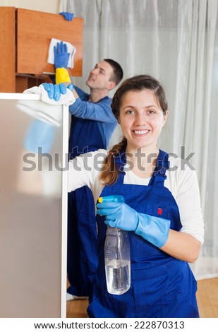 Man and young woman cleaning in living room
