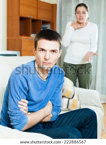 Family quarrel. Sad man listening to woman at home