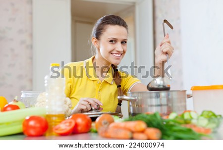 Happy young woman  in yellow tests vegetarian food