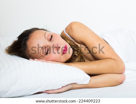 Middle-aged woman sleeping on white pillow at home