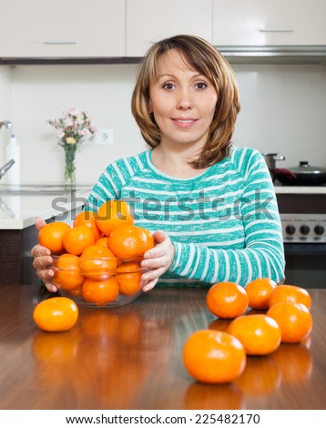 woman with  tangerines in domestic kitchen