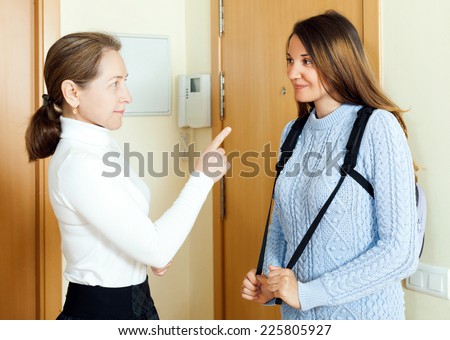 Mature woman say parting words his young daughter at the door from home