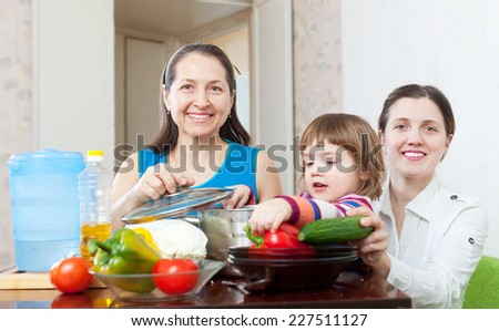 Happy family together cooking vegetarian lunch