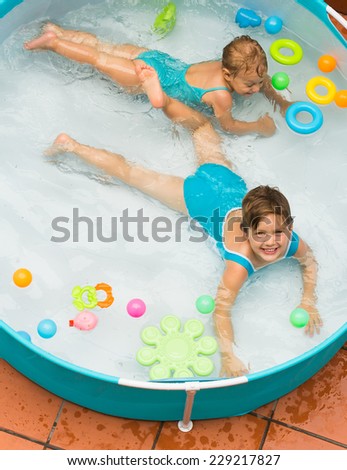 Happy smiling children swimming in kid pool at terrace