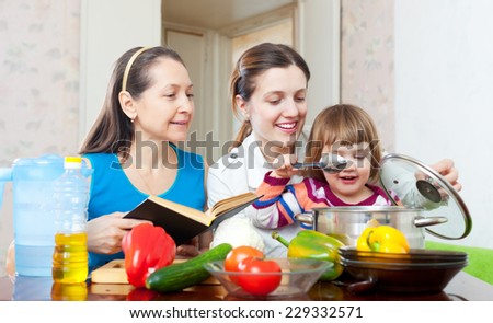 Happy family together cook with cookbook in the kitchen at home