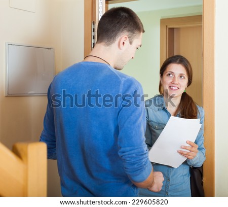 Smiling woman talking with man at door