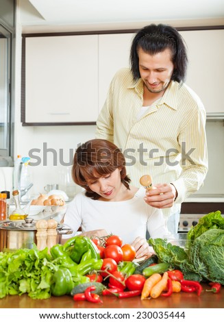 woman and handsome husband cooking with fresh vegetables