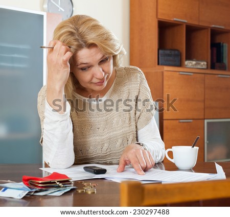 Serious blonde woman thinking about the financial issue at  home