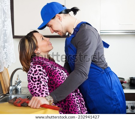 Plumber having flirt with woman in kitchen
