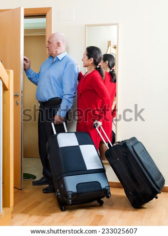 mature man and woman together with luggage leaving the home