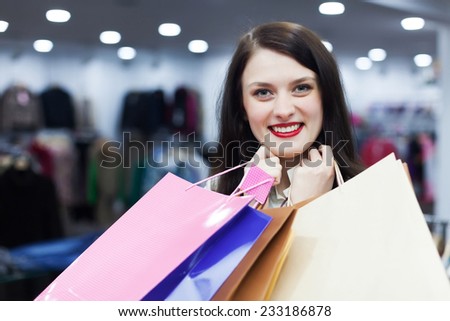 Smiling woman with shopping bags at fashion boutique