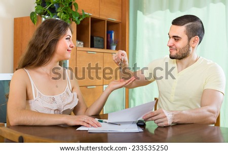 Smiling woman getting the keys from a new apartment