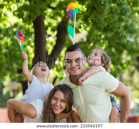 Parents walking with children on bright vacation day at park