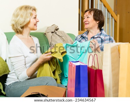 Old woman showing presents to her female friend and smiling