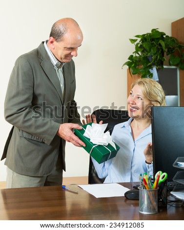 Affair in office: boss giving a present to assistant